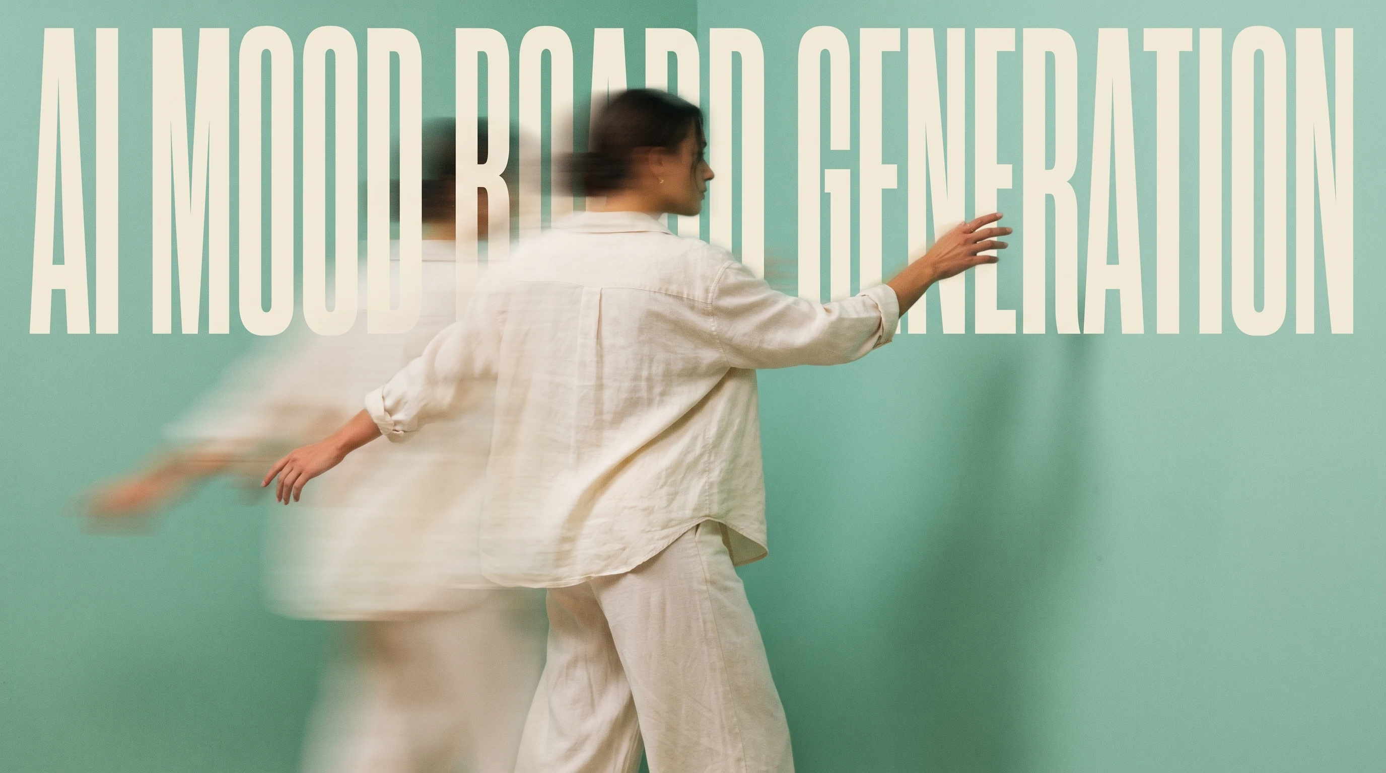 A person mid-turn in a mint-green studio, arms outstretched gesturing toward an unseen wall of pinned reference prints, outfit a loose cream linen
