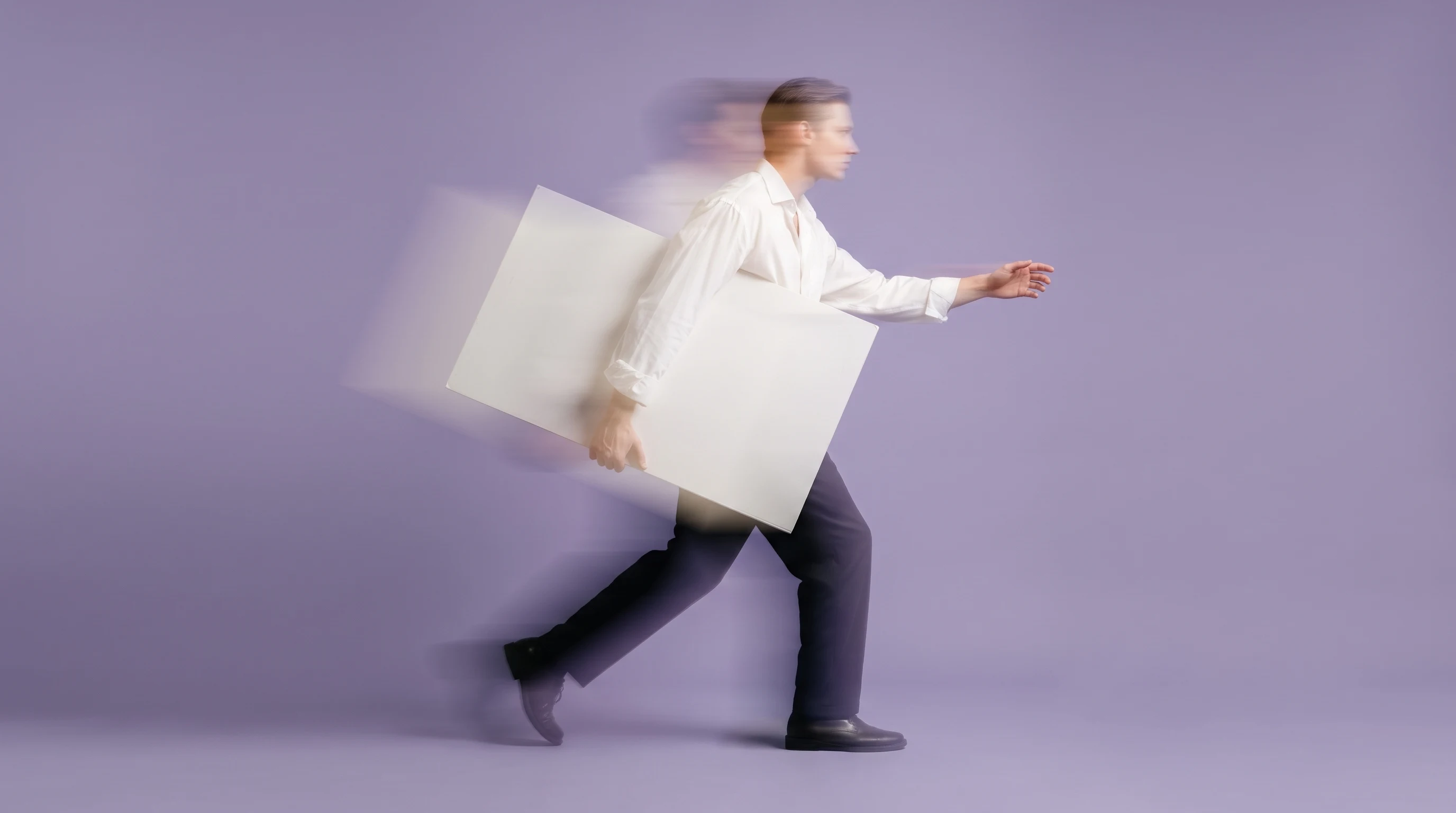 A person mid-step across a lilac-backdrop studio, carrying a large blank storyboard panel under one arm, reaching forward with the other hand, shot